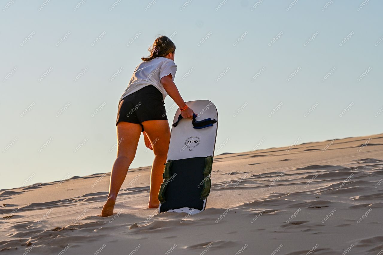 Lagoa da Conceição, Florianópolis: Jovem praticando sandboard em meio às dunas de areia