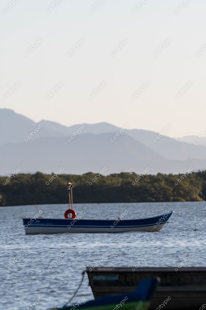 Costeira do Pirajubaé, Florianópolis: Cena serena de uma embarcação azul ao entardecer
