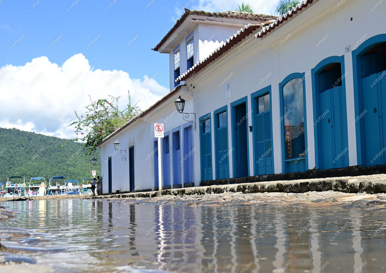 Paraty, Rio de Janeiro: Rua charmosa com edificações históricas e portas azuis sob um céu ensolarado
