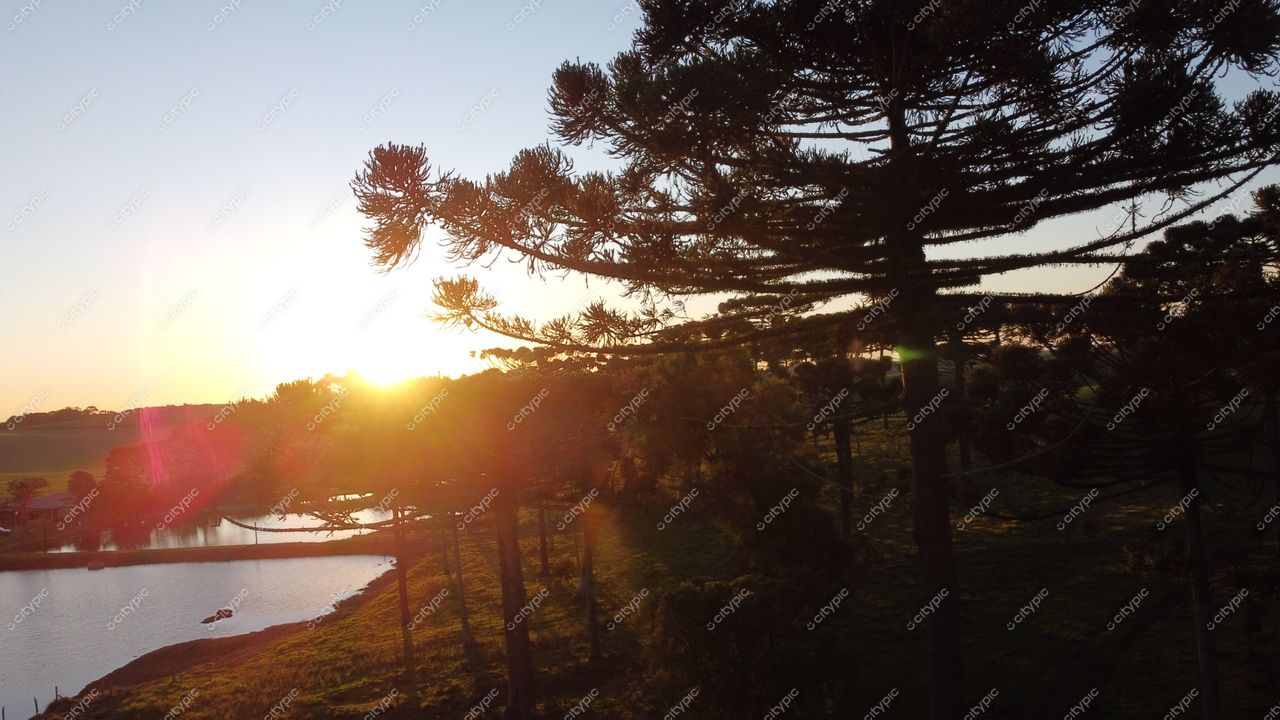 Pôr do sol dourado no lago de Campo Erê, Santa Catarina: um espetáculo de cores quentes e tranquilidade na natureza