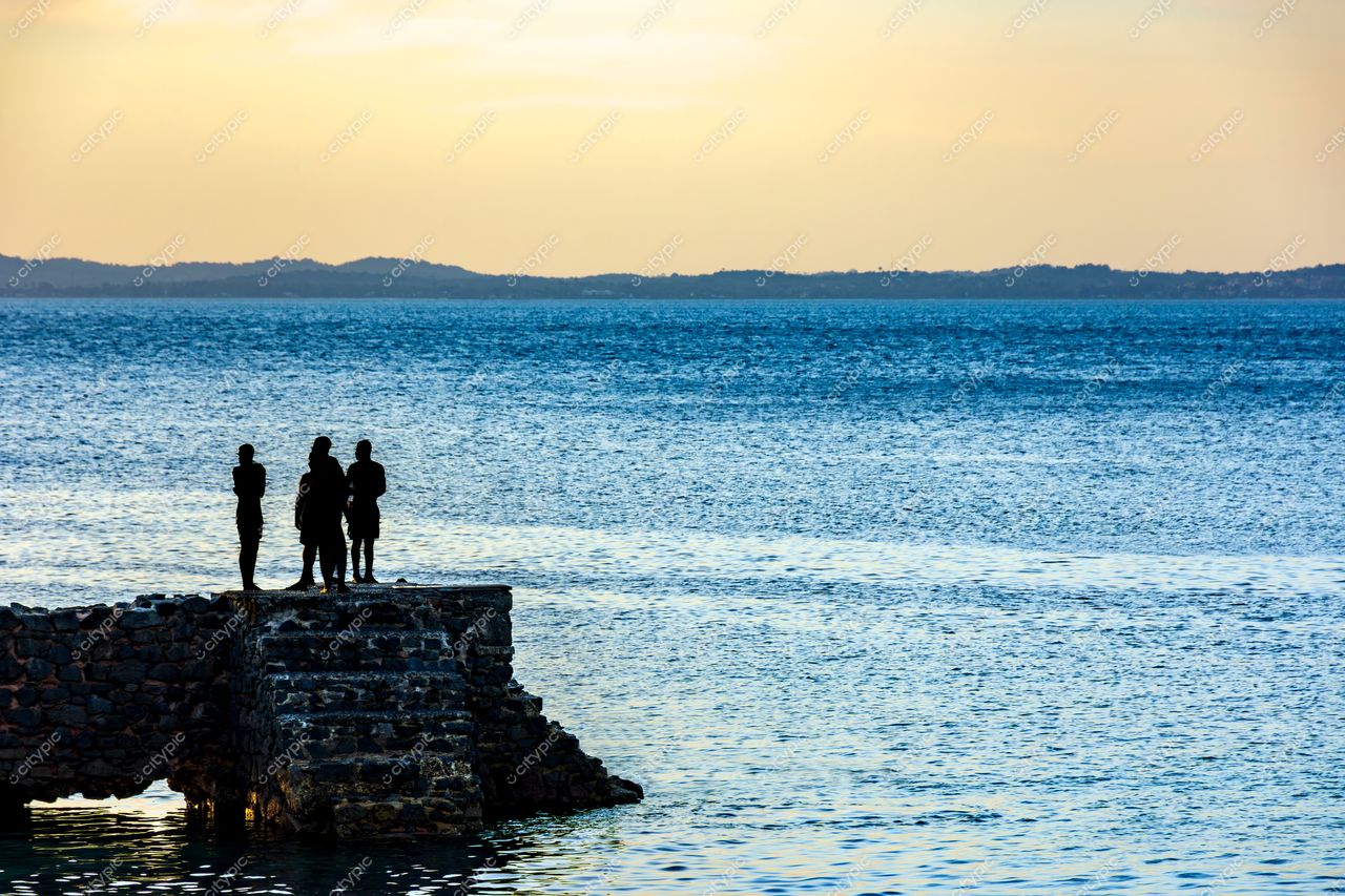 Pôr do sol na Barra, Salvador: Silhuetas contemplativas à beira-mar