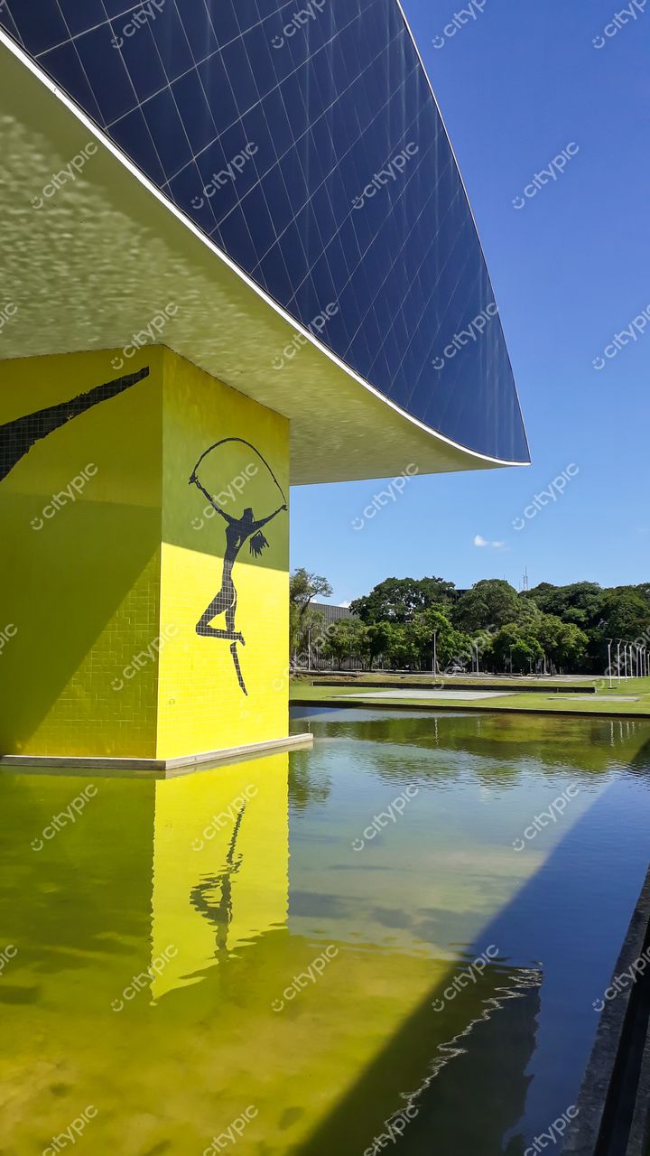 Curitiba, Paraná: Edifício moderno com fachada amarela e painéis solares, em perfeita harmonia com a natureza