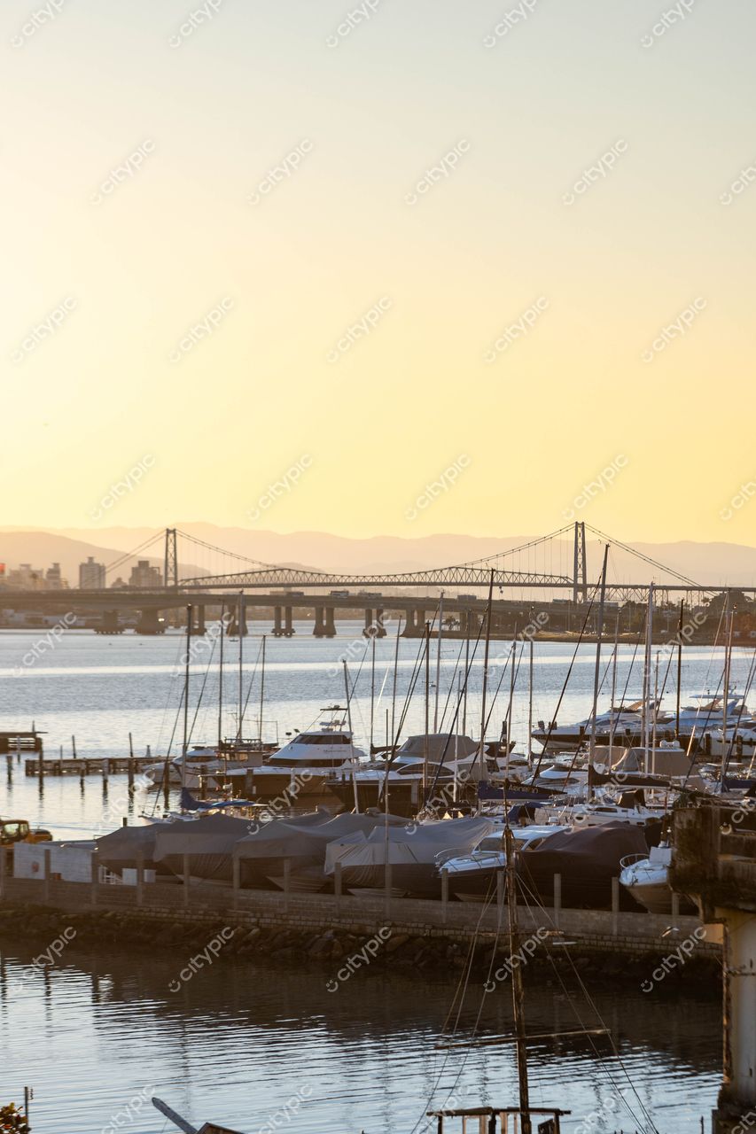 Pôr do sol encantador no Porto de Centro, Florianópolis, Santa Catarina: iates, barcos e ponte elegante em destaque