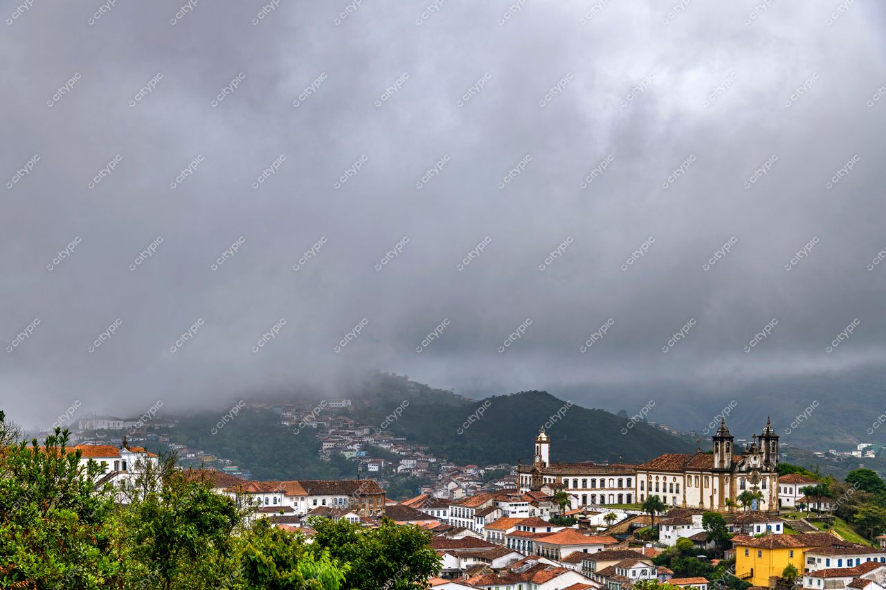 Ouro Preto, Minas Gerais: Vista panorâmica da cidade colonial com igreja barroca e montanhas cobertas por neblina
