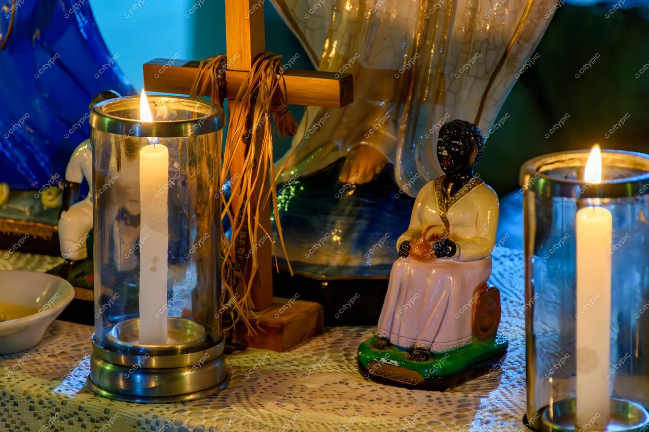 Altar decorado com vela acesa e estatueta sagrada em Belo Horizonte, Minas Gerais: reflexão da cultura religiosa local