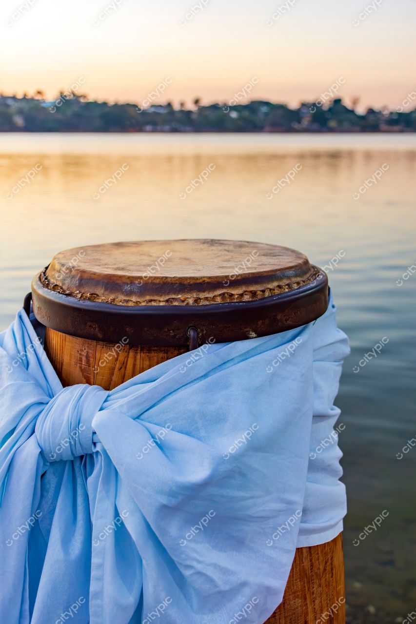 Lago Calmo ao Pôr do Sol: Tambor de Madeira com Laço Azul em Belo Horizonte, Minas Gerais