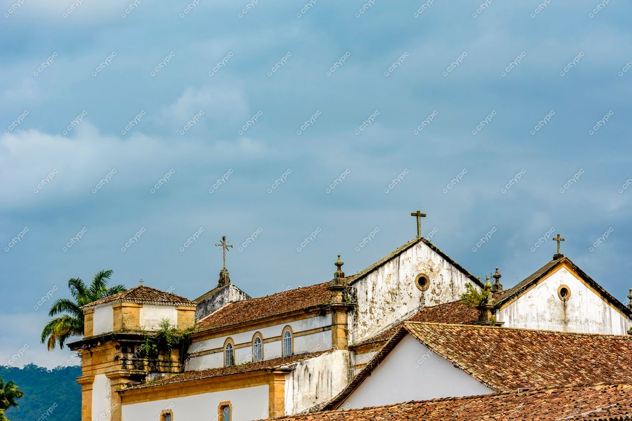Paraty, Rio de Janeiro: Coberturas de igrejas históricas em tons terrosos sob o céu azul