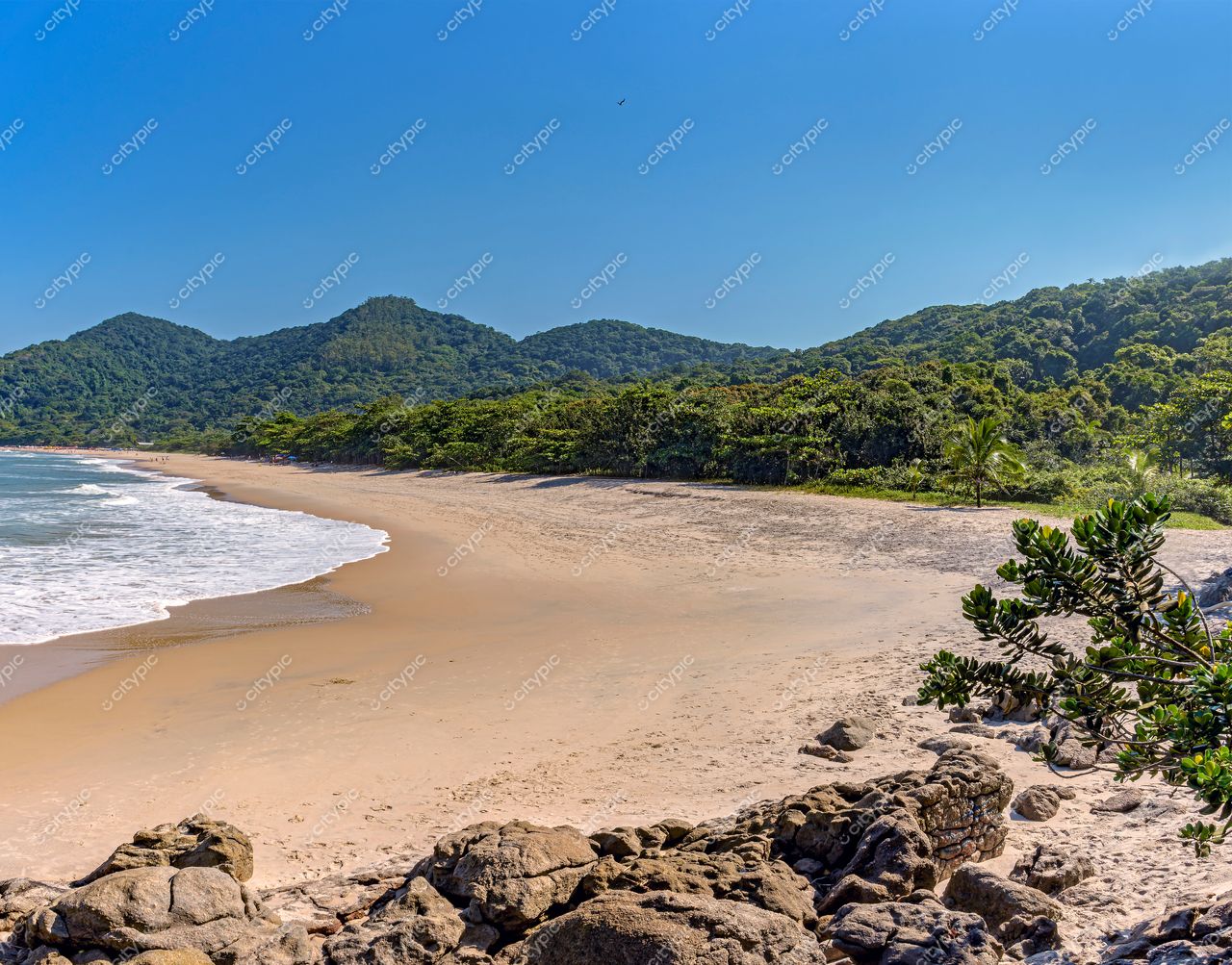 Guarujá, São Paulo: Praia paradisíaca sob céu azul e montanhas verdes