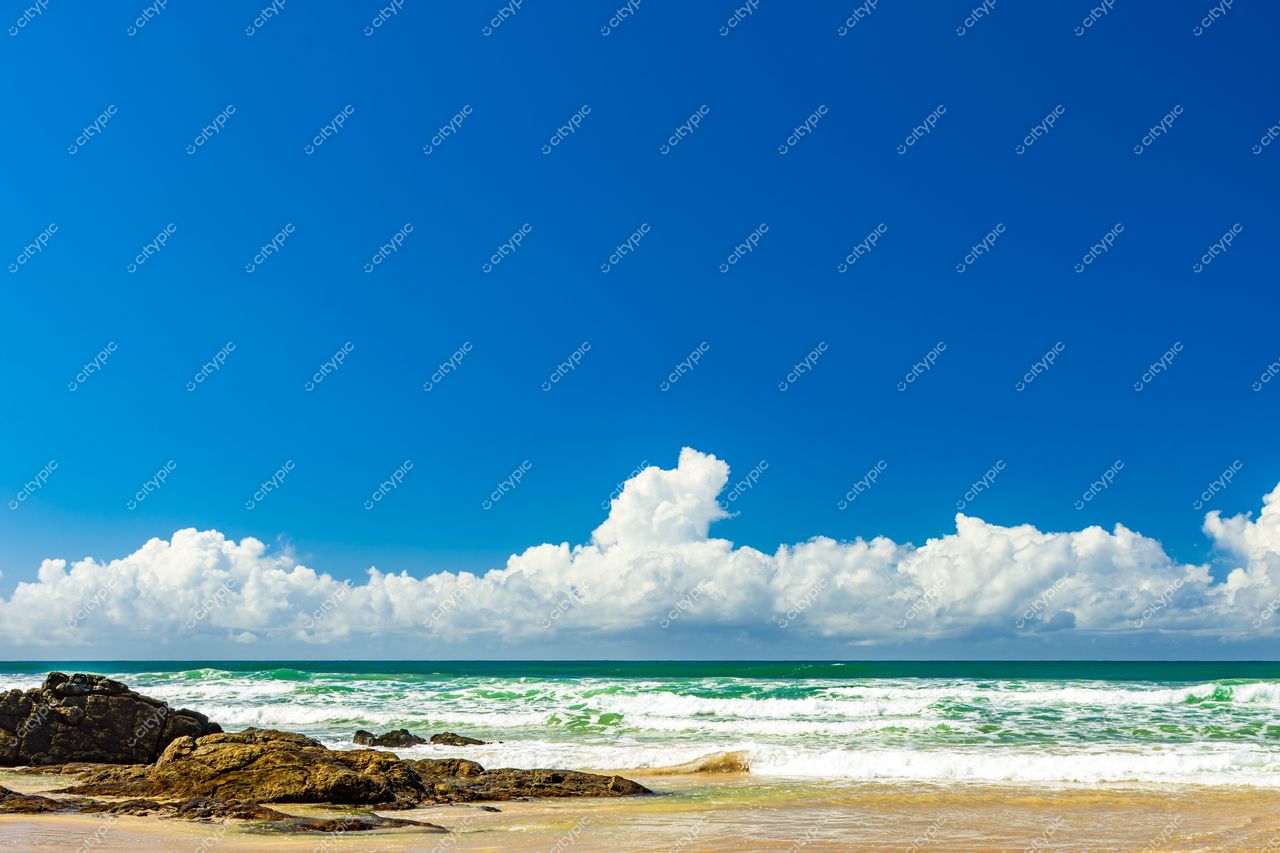 Uruçuca, Bahia: Cena Serena de Praia com Céu Azul e Ondas Suaves