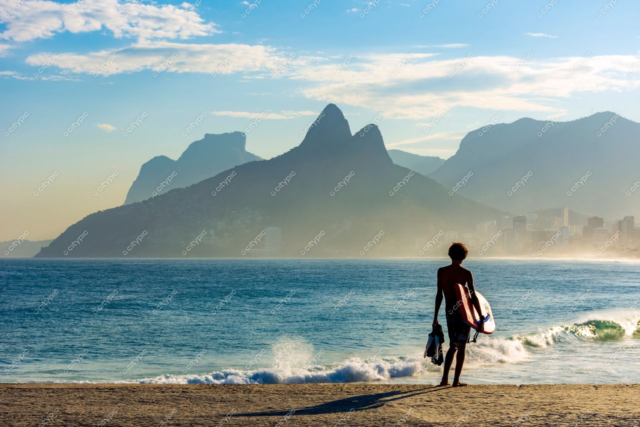Ipanema, Rio de Janeiro: Surfista contemplando o amanhecer no mar com as montanhas do Morro Dois Irmãos ao fundo
