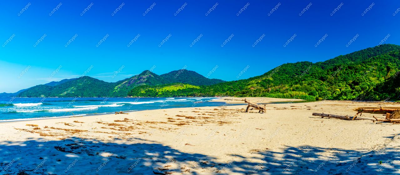 Ilhabela, São Paulo, Brasil: Praia deslumbrante sob o céu azul e montanhas verdes ao fundo