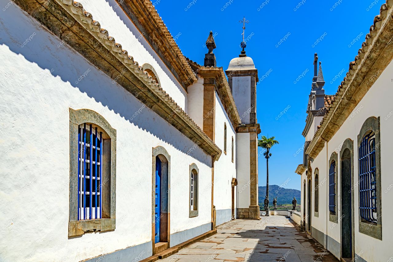 Congonhas, Minas Gerais: Rua tranquila com edificações históricas e igreja ao fundo