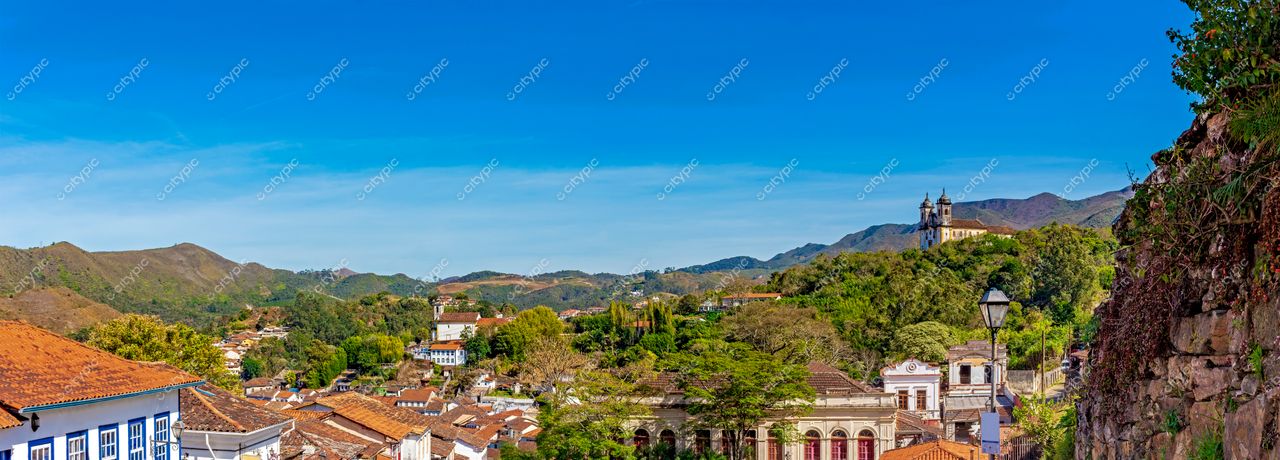 Ouro Preto, Minas Gerais: Vista panorâmica da cidade histórica com céu azul e montanhas ao fundo