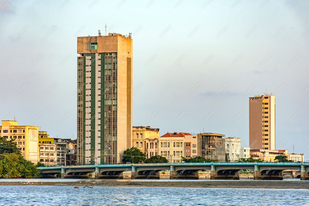 Recife, Pernambuco: Panorama urbano com torres modernas e viaduto sobre rio calmante