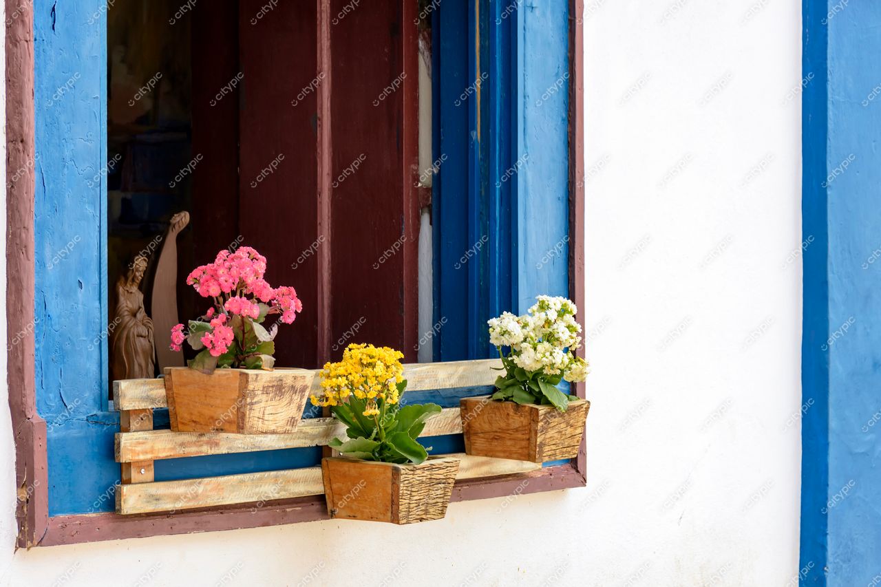 Tiradentes, Minas Gerais: Janela com molduras azuis e vasos de flores vibrantes