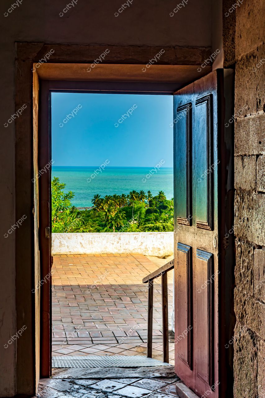 Porta de Madeira Aberta com Vista para o Mar em Olinda, Pernambuco: Conexão com a Natureza e Tranquilidade