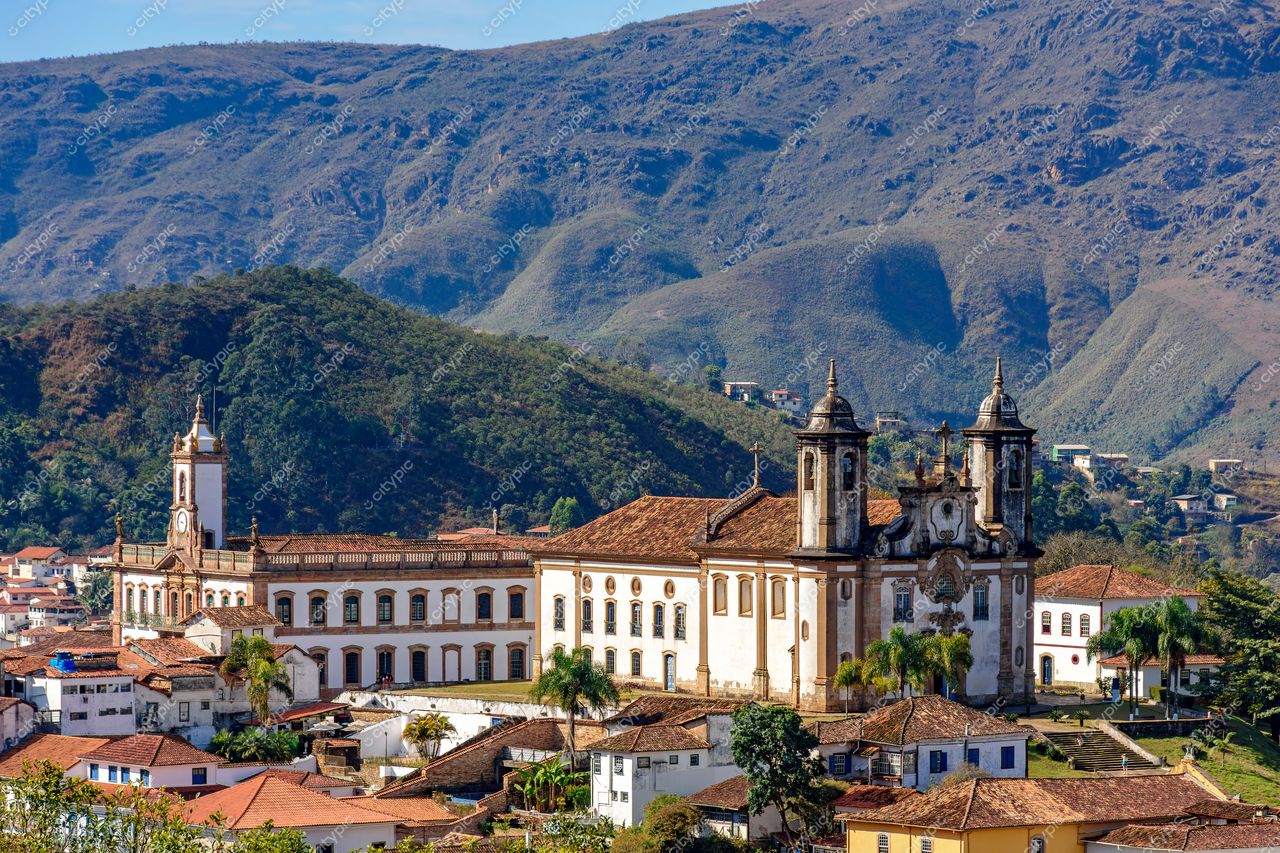 Ouro Preto, Minas Gerais: Vista panorâmica da cidade histórica com edifício imponente e montanhas verdejantes ao fundo