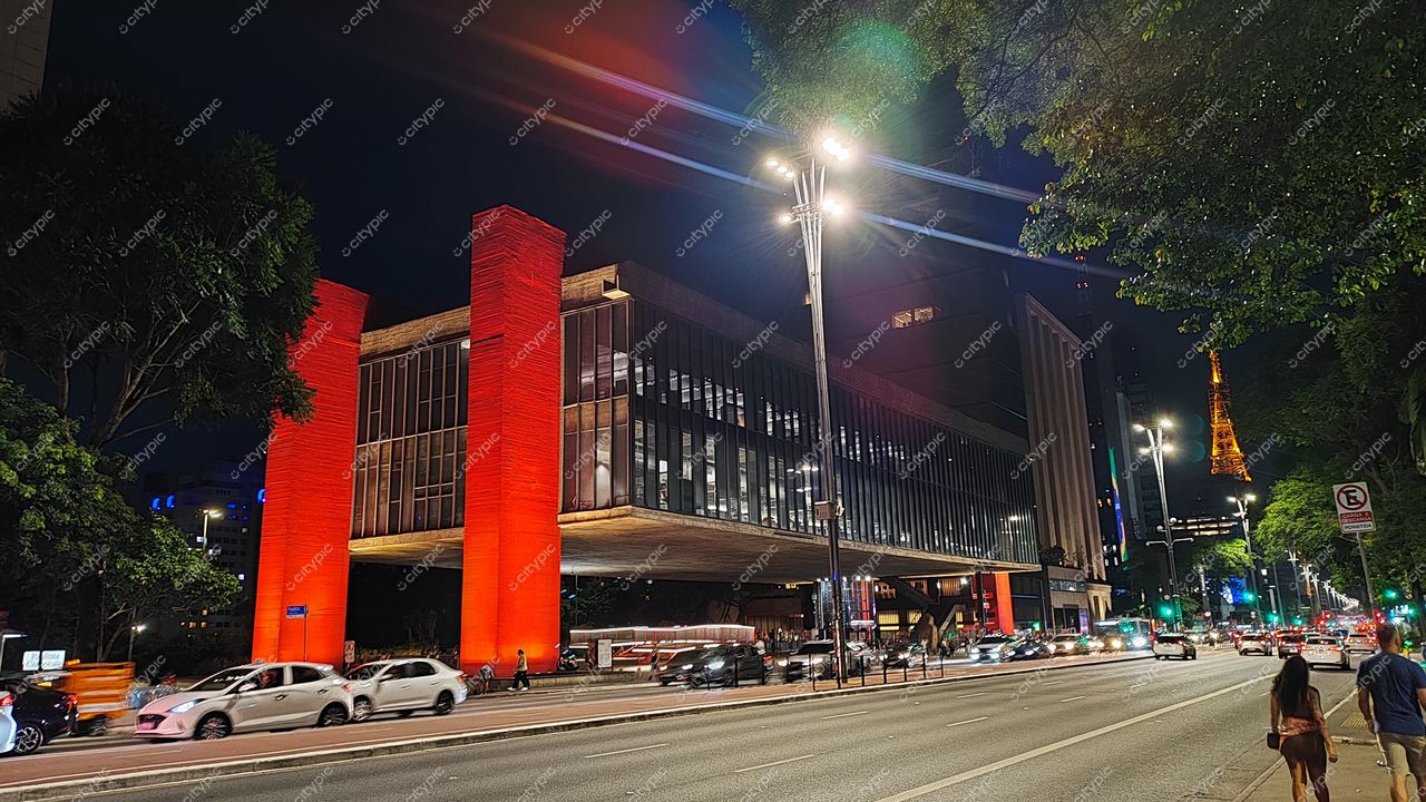 São Paulo, Brasil: Edifício Moderno Iluminado em Tons de Vermelho com a Torre Eiffel do Brasil ao Fundo