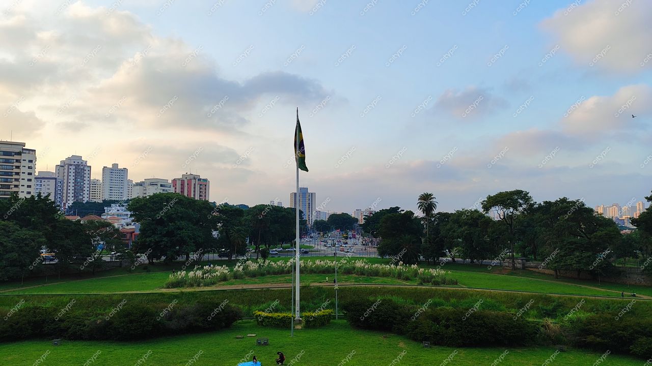 São Paulo, Brasil: Parque com bandeira do Brasil ao centro e skyline urbano ao fundo