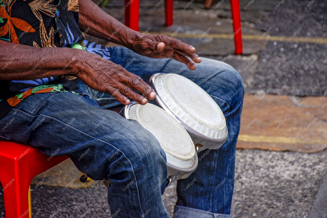 Pelourinho, Salvador: Músico de Bongôs com mãos envelhecidas e camisa colorida
