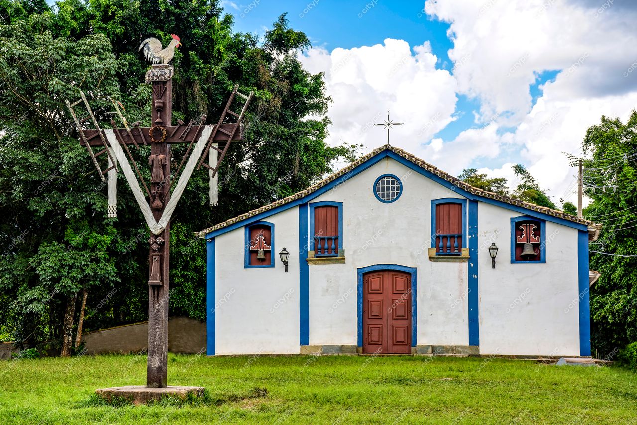 Tiradentes, Minas Gerais: Capela colonial com cruz ornamentada e galo esculpido