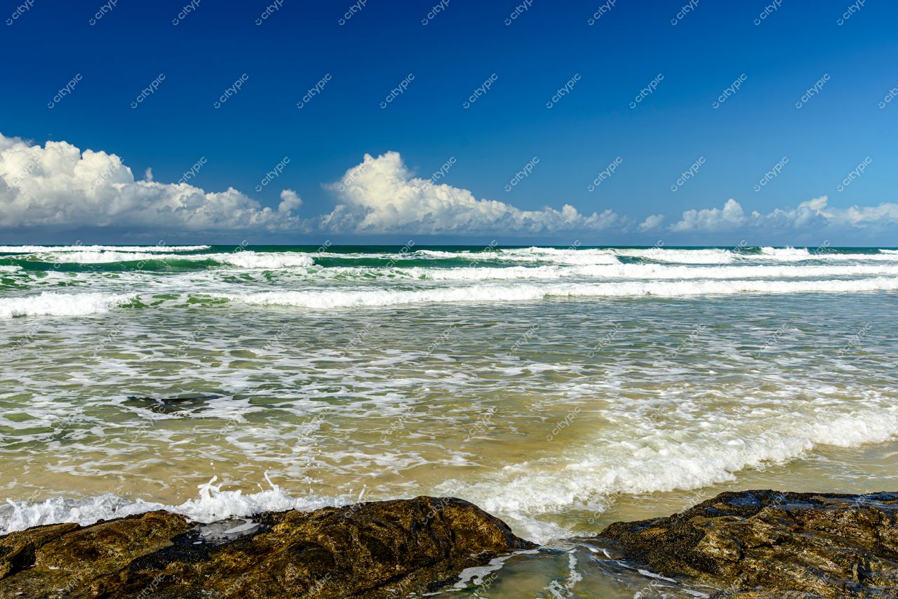 Uruçuca, Bahia: Cena Serena de Praia com Ondas Suaves e Céu Azul Vibrante
