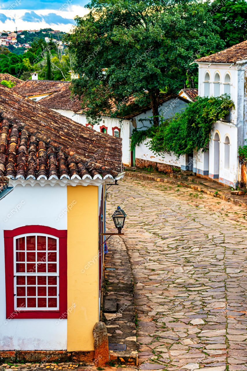 Tiradentes, Minas Gerais: Rua de paralelepípedos com charme colonial e montanhas ao fundo