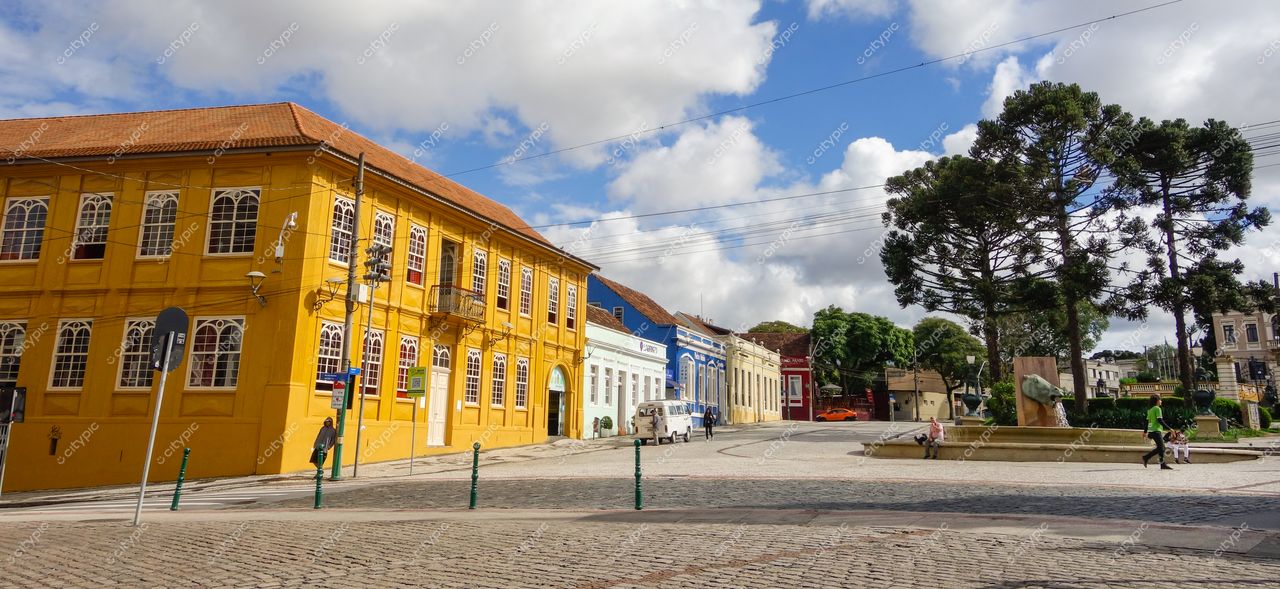 Curitiba, Paraná: Praça encantadora com prédio histórico amarelo e cores vibrantes