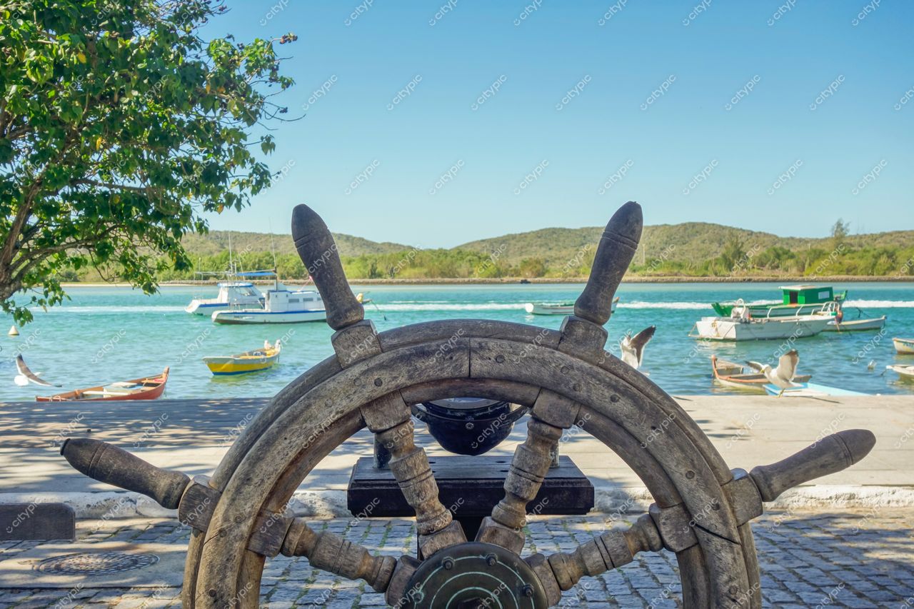 Cabo Frio, Rio de Janeiro: Roda de leme antiga em destaque na paisagem marítima tranquila