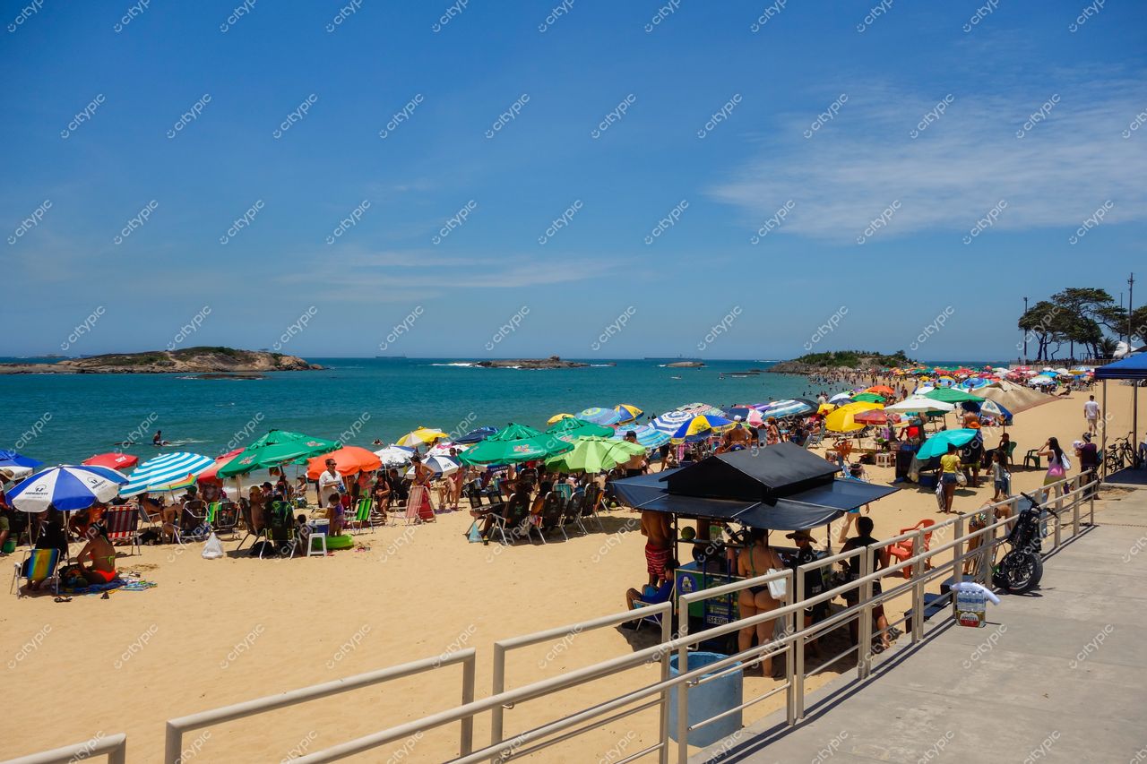 Vila Velha, Espírito Santo, Brasil: Cena animada de praia com guarda-sóis coloridos e mar calmo ao fundo