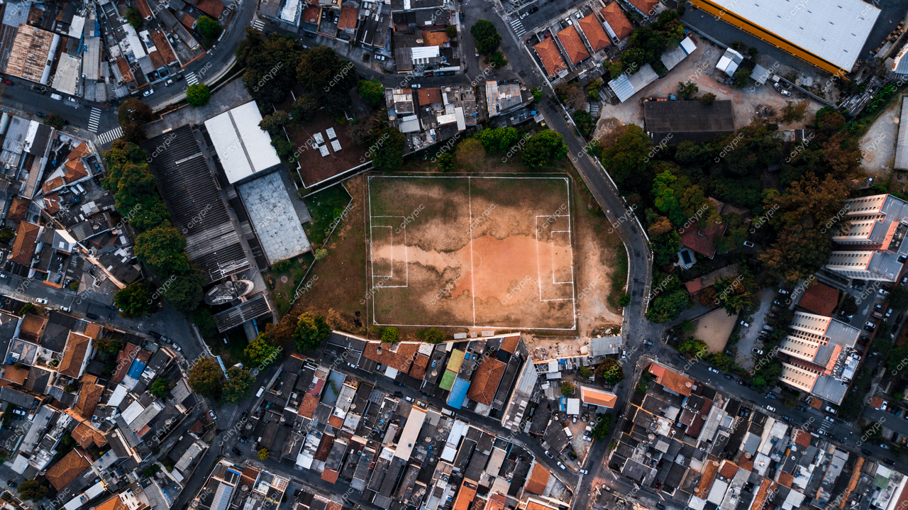 São Paulo, Brasil: Campo de futebol cercado por vegetação em meio à densa urbanização da metrópole