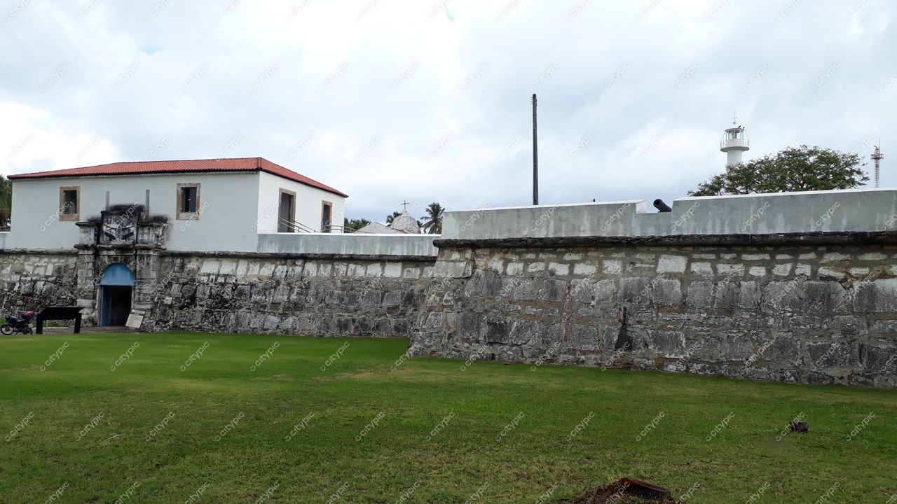 Tamandaré, Pernambuco, edifício de dois andares com telhado vermelho e muro de pedras em dia nublado