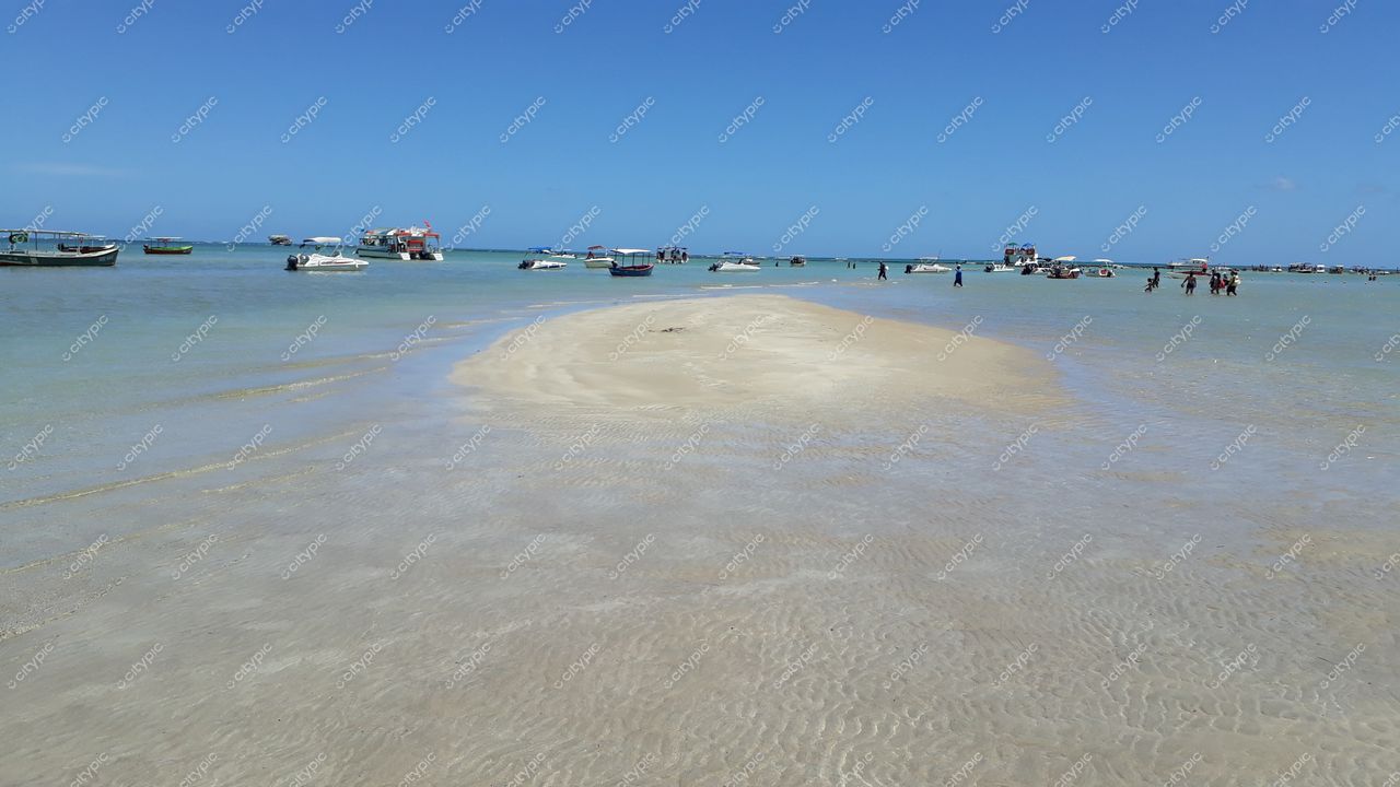 Tamandaré, Pernambuco, dia ensolarado com águas rasas e embarcações ancoradas em uma praia tranquila