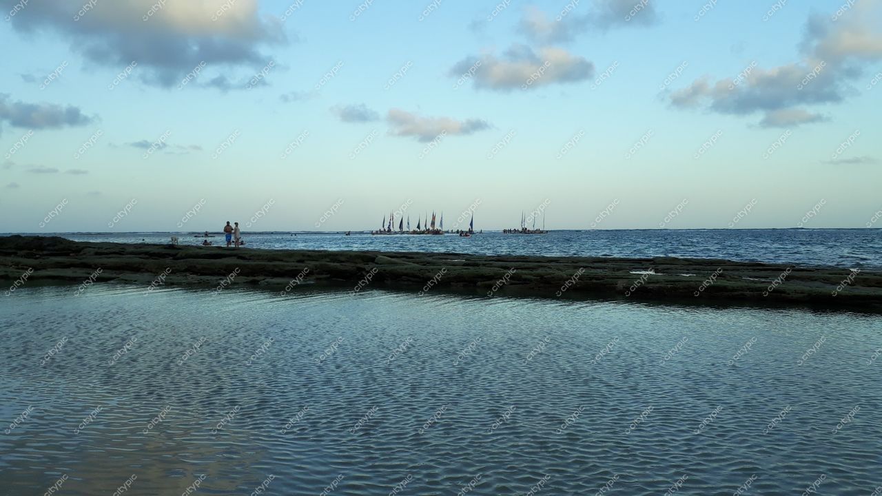 Porto de Galinhas, Pernambuco vista serena do mar ao entardecer com embarcações e formações rochosas na areia