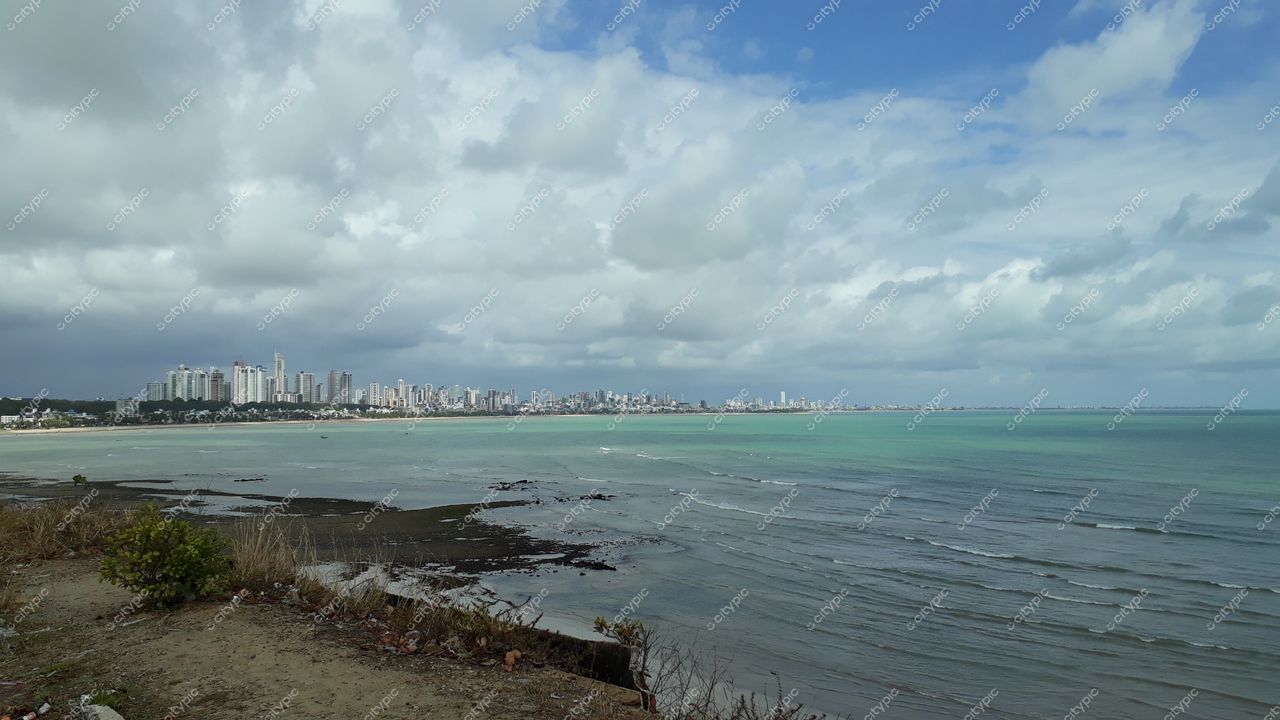 João Pessoa, Paraíba vista panorâmica da orla em dia nublado com rochas expostas e arranha-céus ao fundo