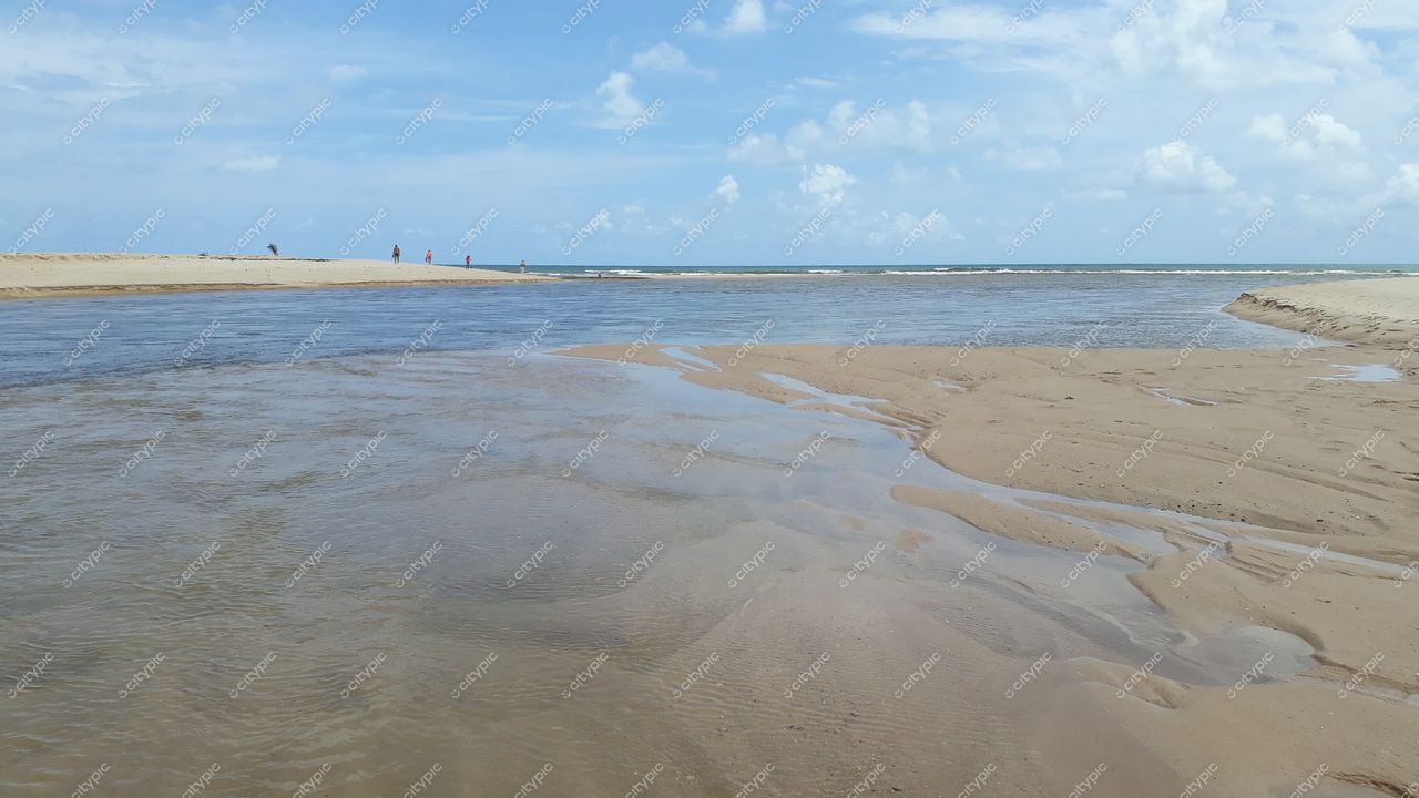 Conde, Paraíba, foz do rio encontrando o mar em dia ensolarado com pessoas na orla e céu claro