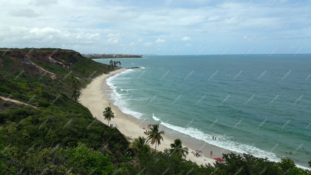 Conde, Paraíba, vista costeira com praia de areia clara, vegetação densa e mar em tons azuis durante o dia