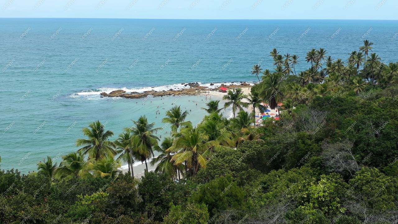 Conde, Paraíba, vista panorâmica da costa com mar azul e verde, rochas, areia clara e vegetação exuberante