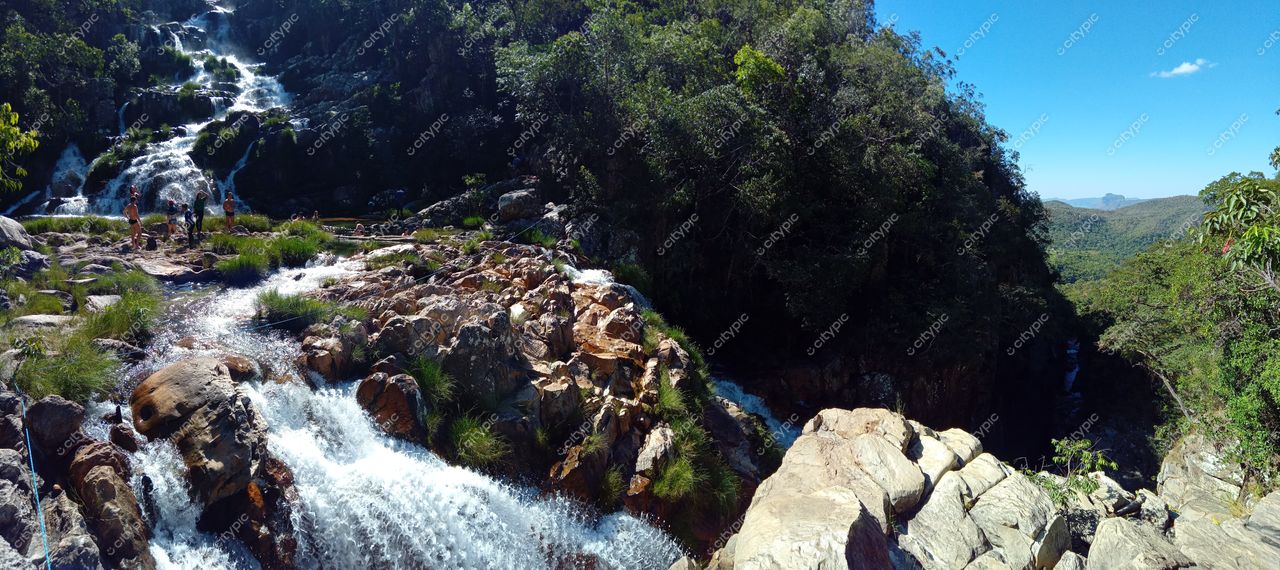 Chapada dos Veadeiros, Goiás, rochas expostas com água corrente em meio à vegetação densa durante o dia