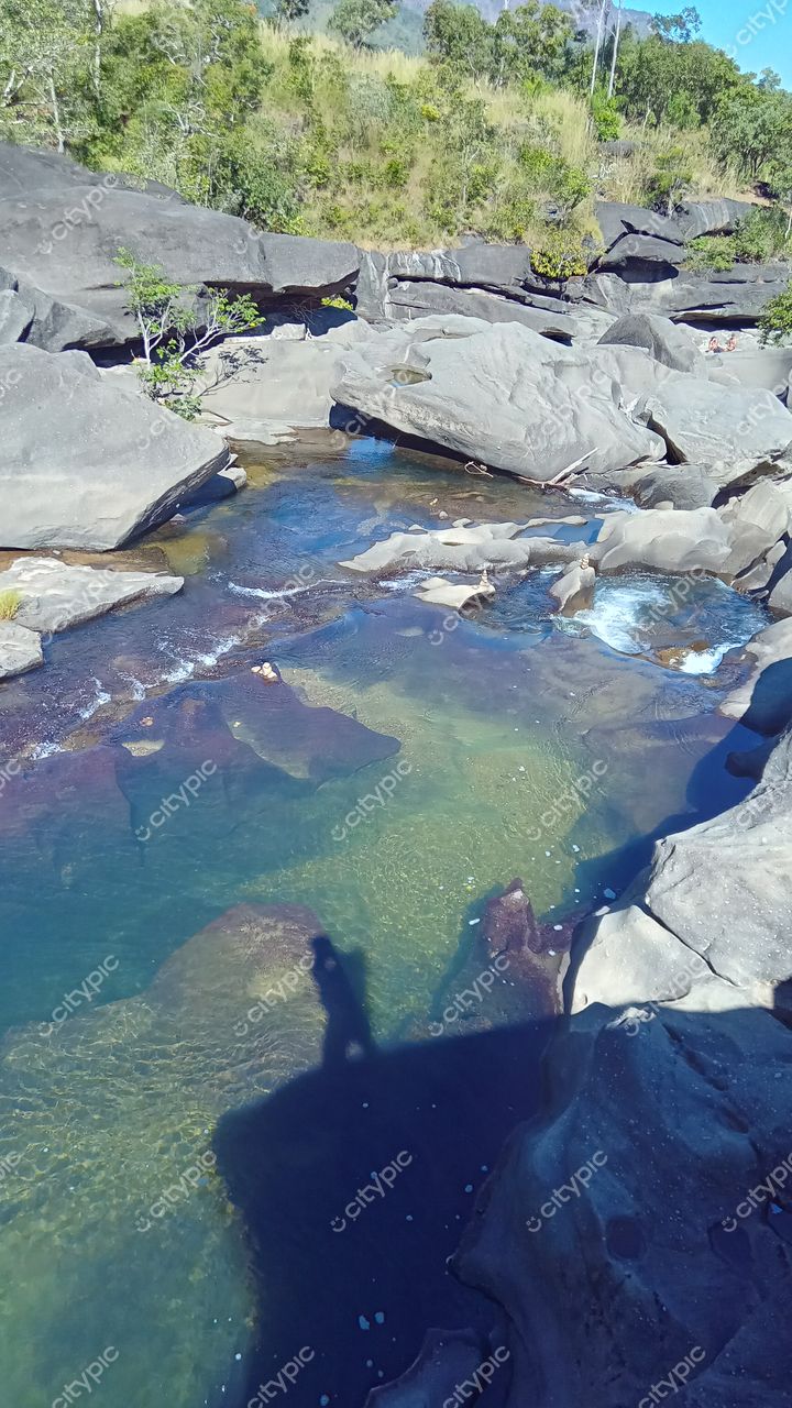Chapada dos Veadeiros, Goiás, formação rochosa com água clara refletindo azul e verde em ambiente natural iluminado pelo sol