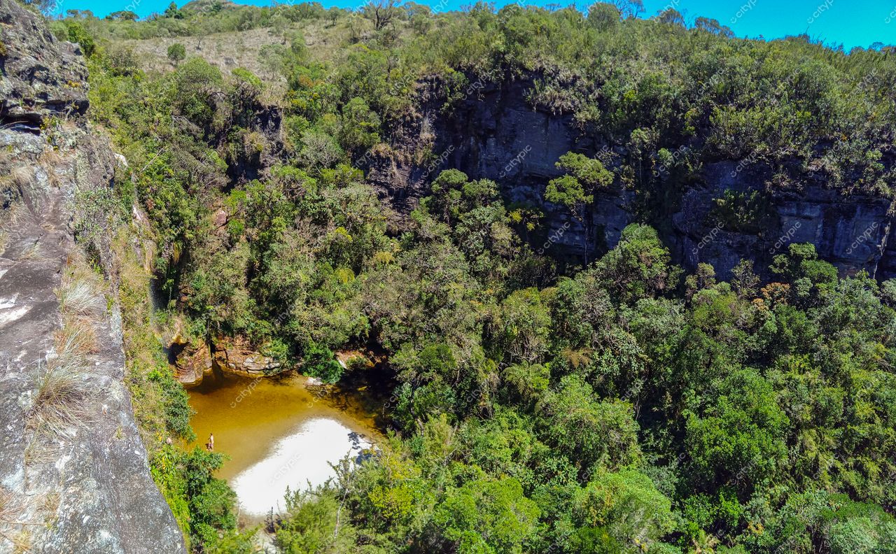 Ibitipoca, Minas Gerais vista panorâmica de cânion com piscina natural e vegetação densa em dia ensolarado