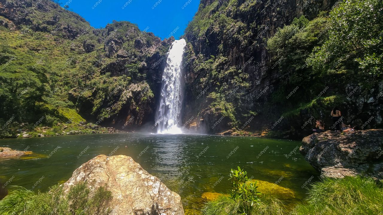 Serra da Canastra, Minas Gerais, cachoeira com neblina e luz solar intensa, lago esverdeado e vegetação exuberante