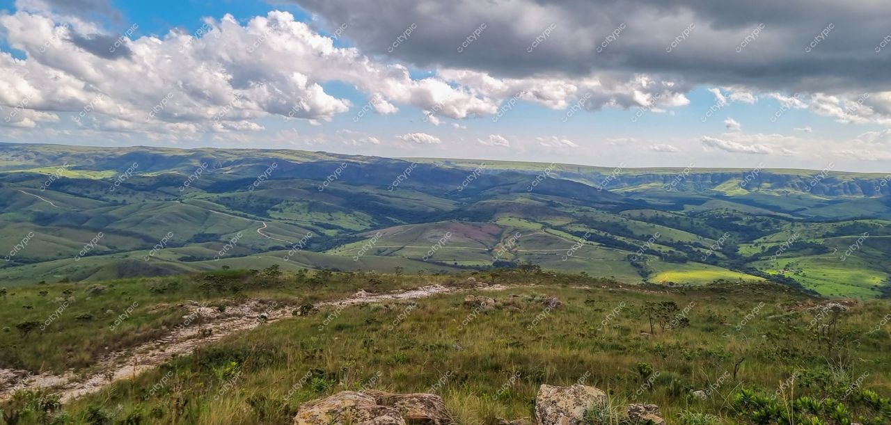 Serra da Canastra, Minas Gerais com colinas verdes, céu azul e nuvens brancas sobre a vegetação exuberante
