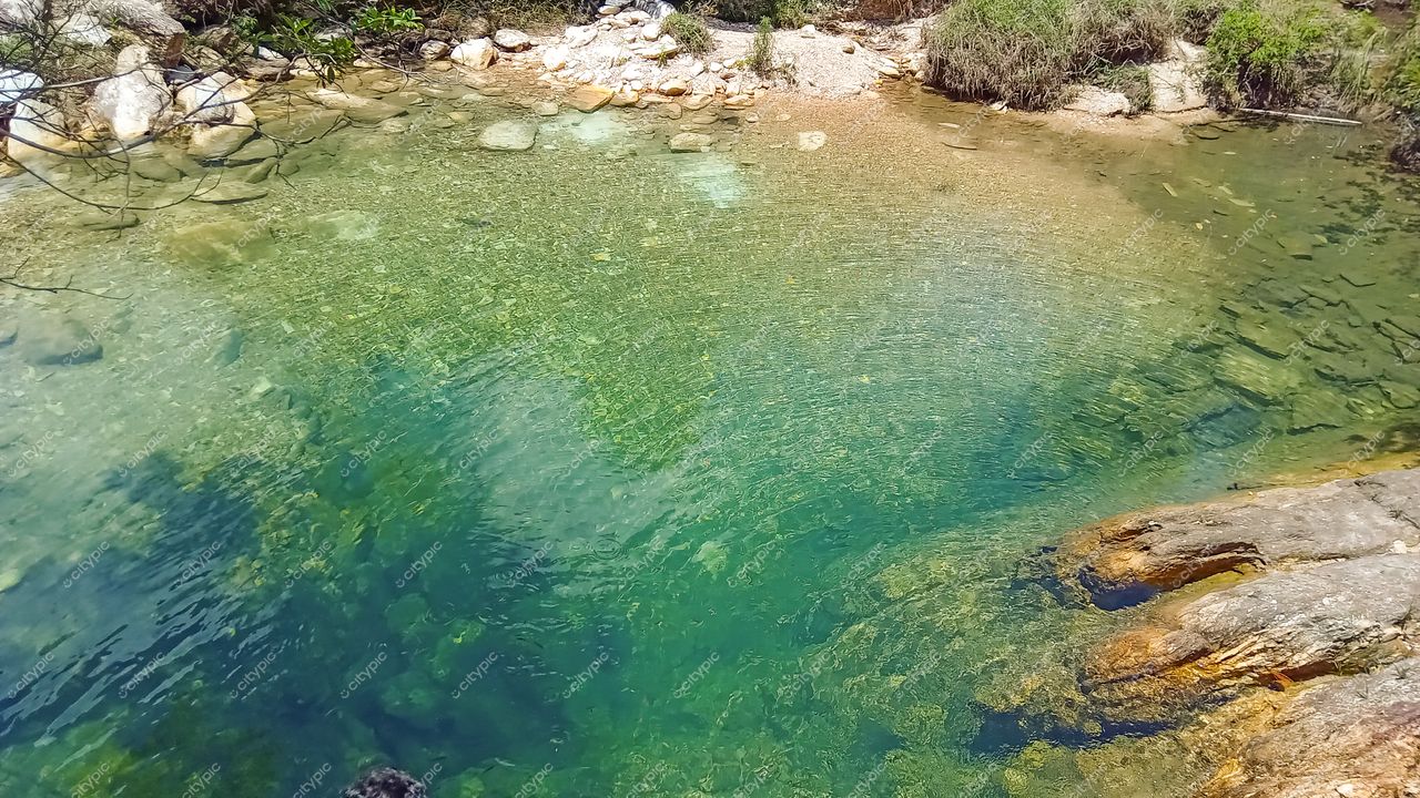 Serra da Canastra, Minas Gerais, clareira com corpo d’água esmeralda em dia ensolarado e vegetação rasteira