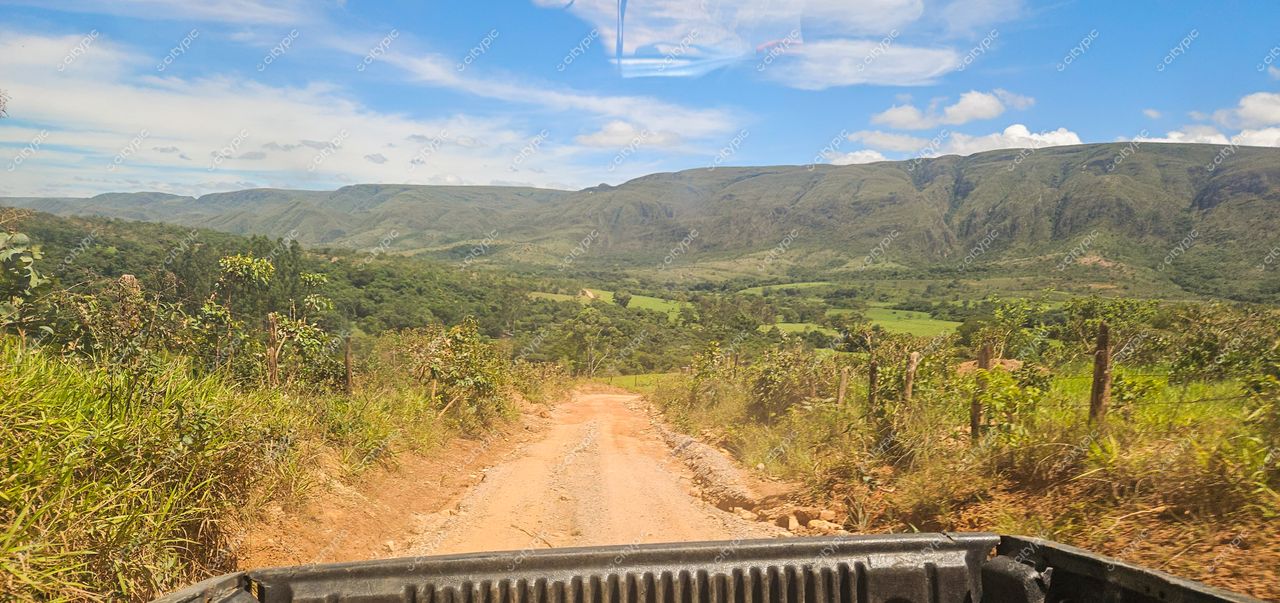 Serra da Canastra, Minas Gerais, estrada de terra em dia ensolarado com vegetação exuberante e céu azul claro