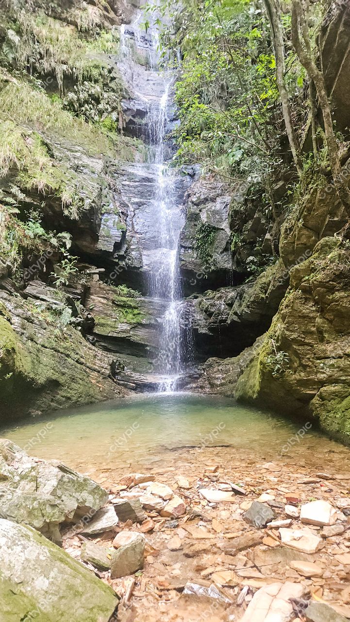 Serra da Canastra, Minas Gerais, cachoeira com água jorrando sobre rochas cobertas de musgo e lago raso