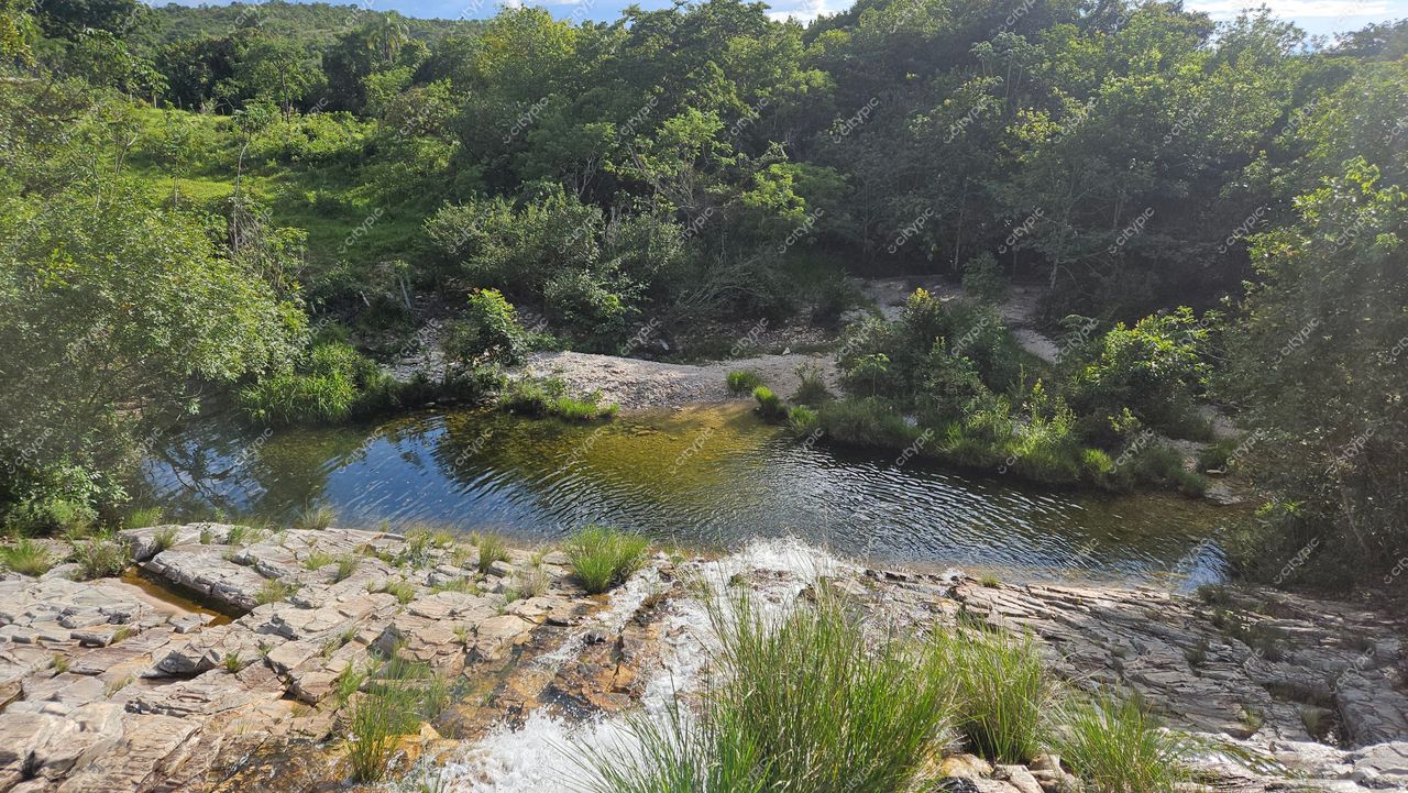 Serra da Canastra, Minas Gerais com pequeno rio sereno cercado por vegetação exuberante e rochas expostas ao sol