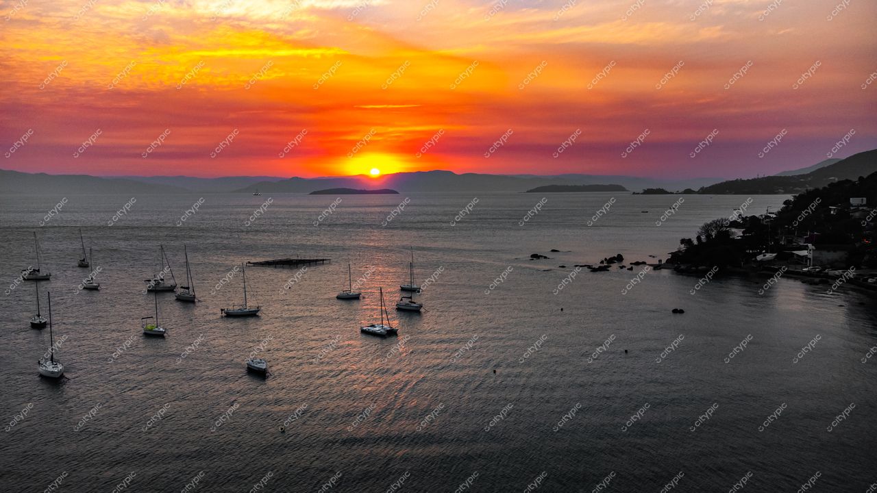 Florianópolis, Santa Catarina, pôr do sol vibrante sobre a baía com iates ancorados e montanhas ao fundo