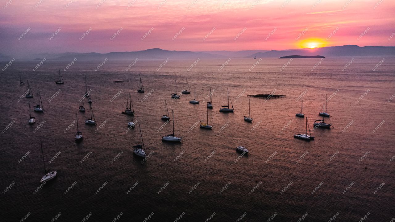 Florianópolis, Santa Catarina, pôr do sol com veleiros na baía e montanhas ao fundo em tonalidades suaves