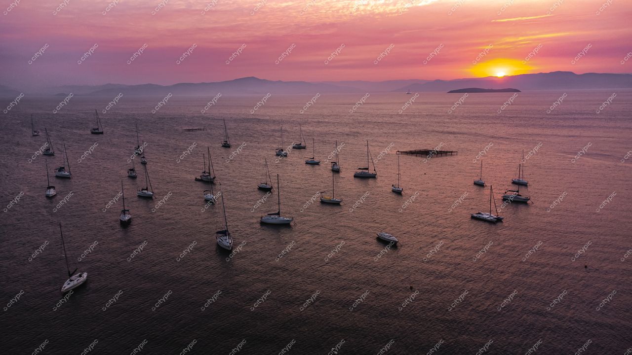 Florianópolis, Santa Catarina, pôr do sol com céu rosa e laranja refletido em baía tranquila com barcos à vela